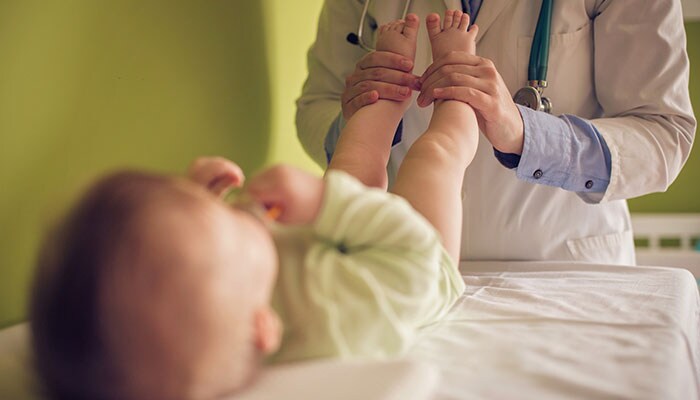 Doctor testing infant's reflexes