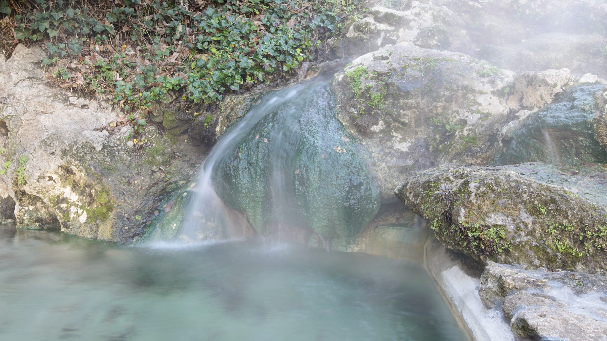 Hot springs with steam coming off rocks and water