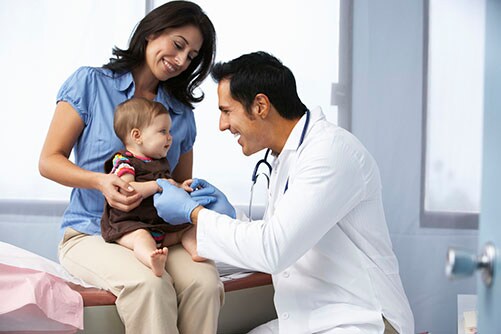 Doctor In Surgery Examining Baby Girl