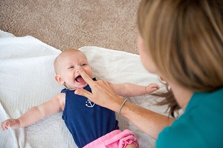 Mother playing with her baby on the ground