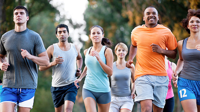 A diverse group of adults jogging outside