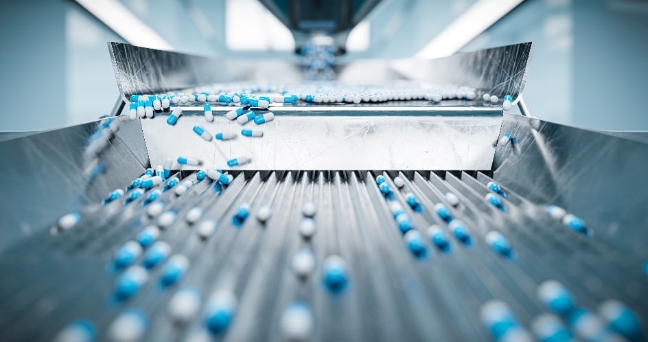 Photo of pharmaceutical pills sliding down a metal dispenser