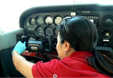 NIOSH industrial hygienist collecting surface wipe sample for lead in an airplane cockpit