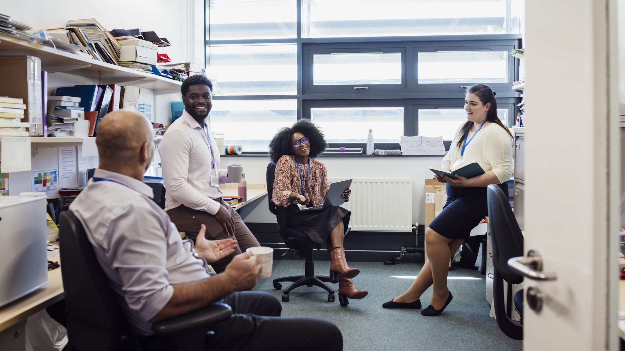 four people sitting in an office talking to each other