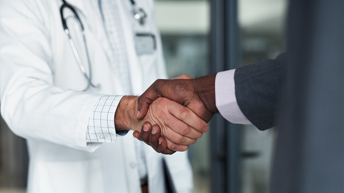 Closeup of a handshake between a physician and executive.