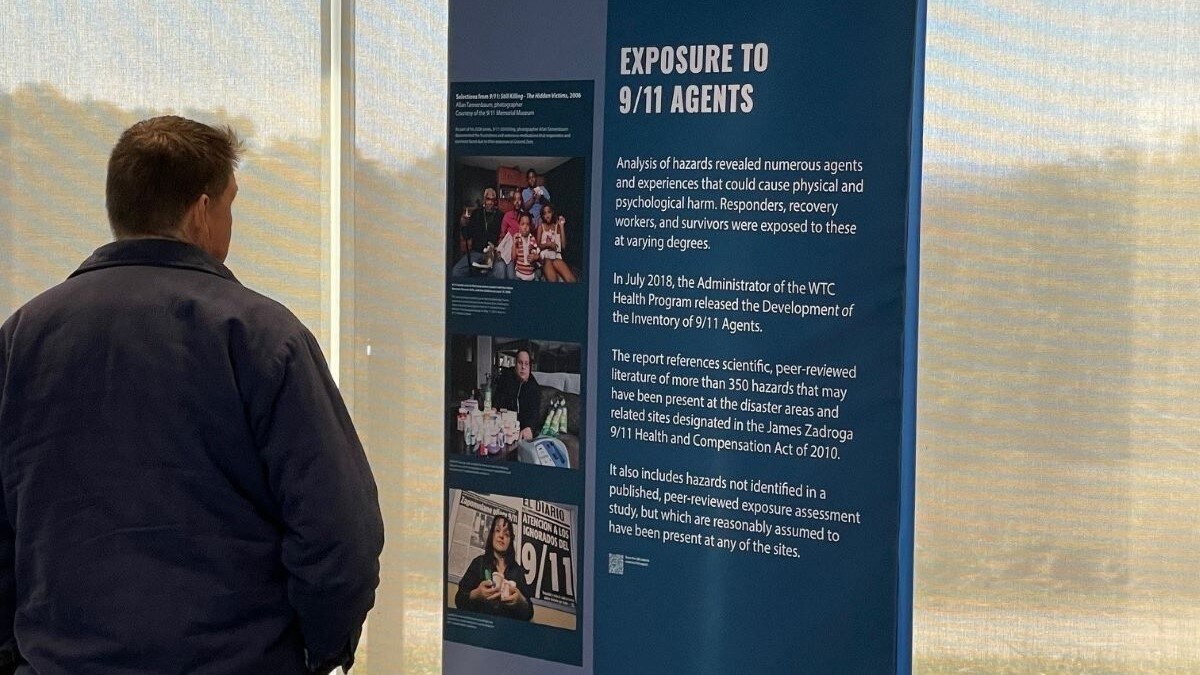 Man looking at exhibit banner about exposure to 9/11 agents