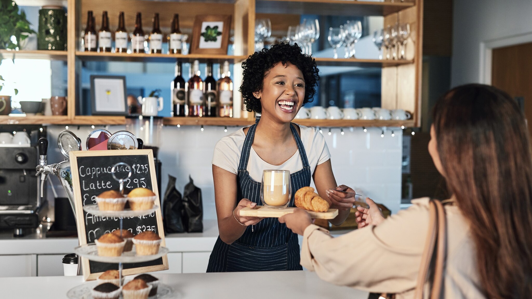 Young female worker handing food to customer.