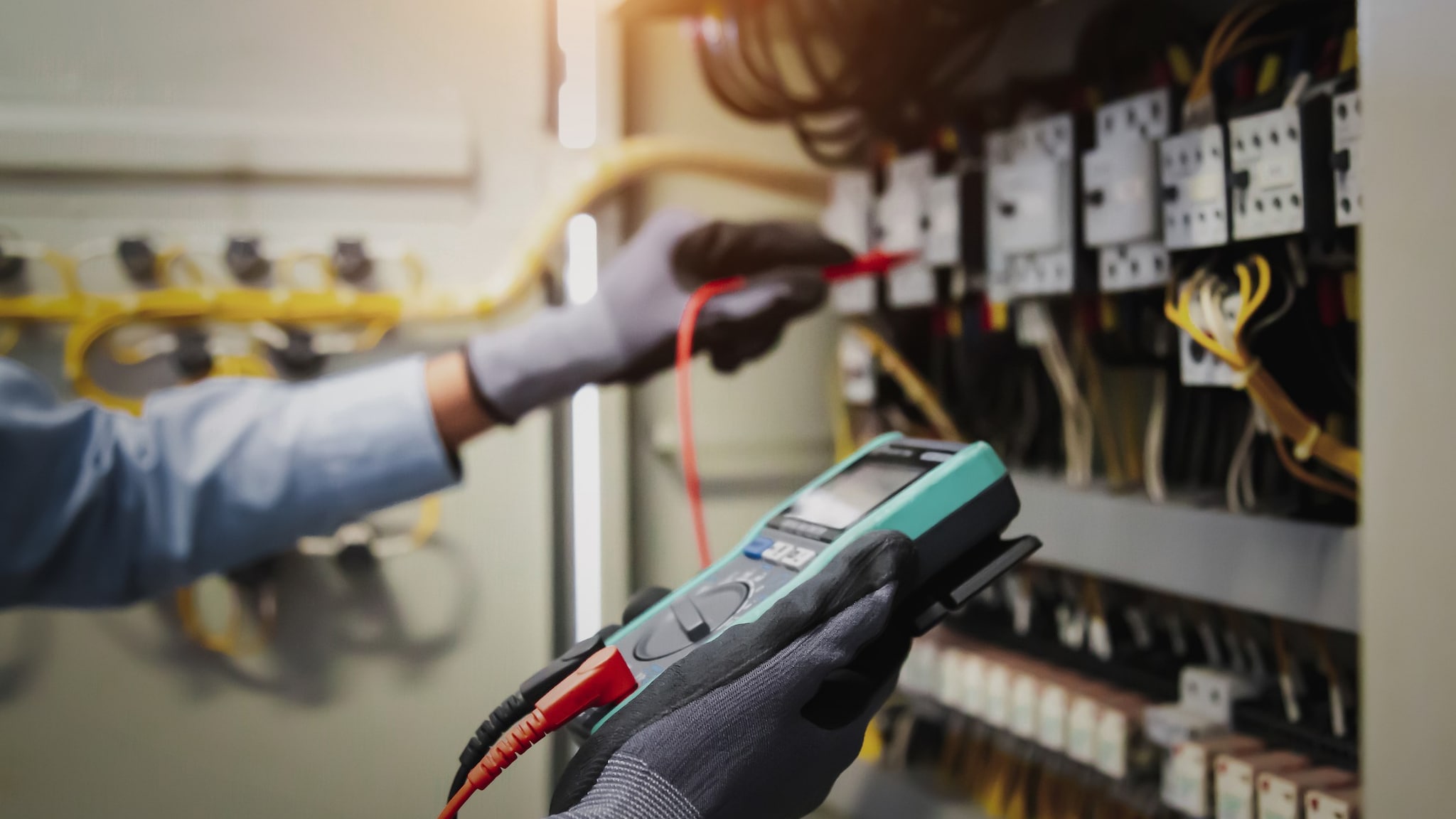 A person using a voltage tester to verify electrical power.