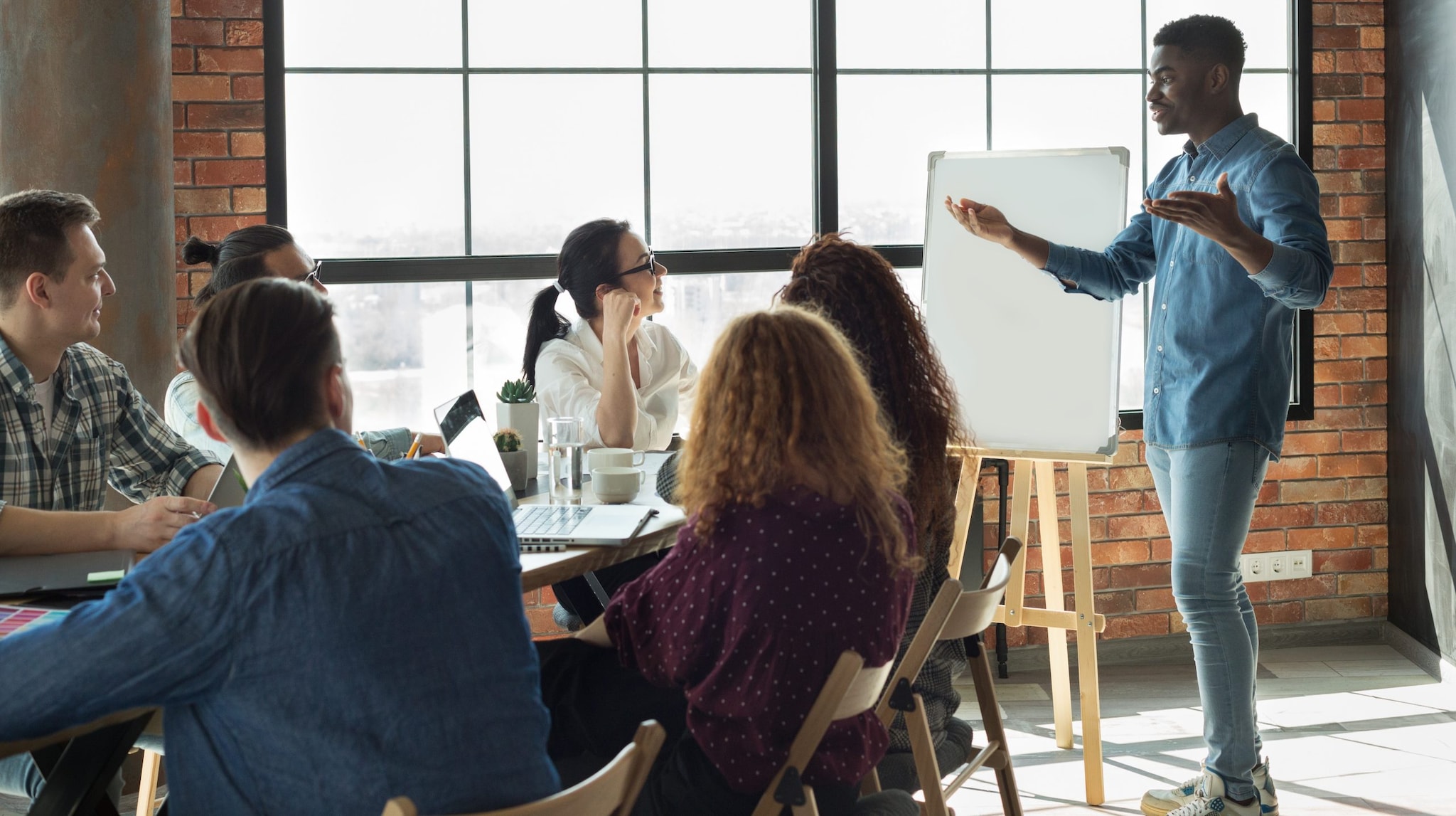 Man standing up in front of coworkers giving a presentation