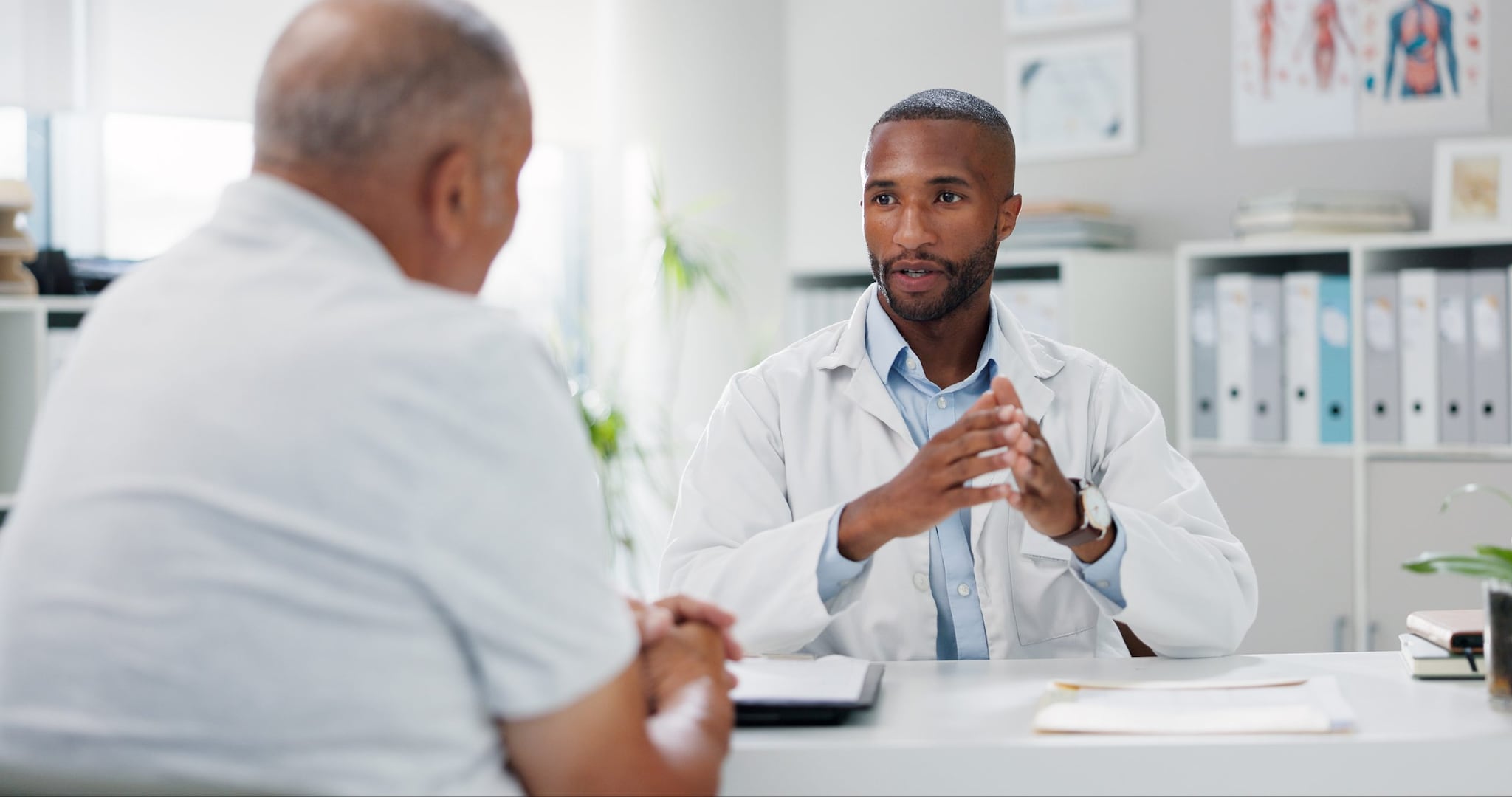 Clinician and patient talking at a desk.