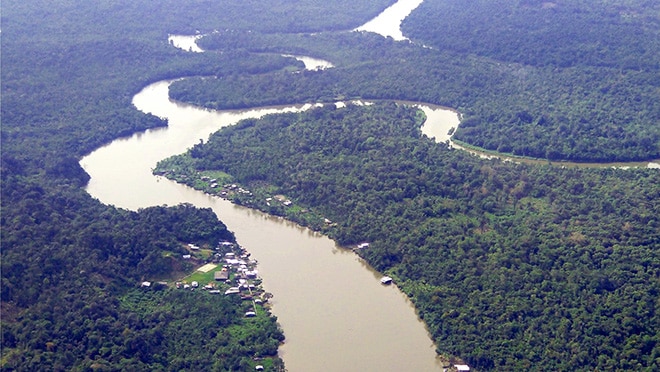 Arial view of the Cauca region, showing a winding river and a heavily forested area.