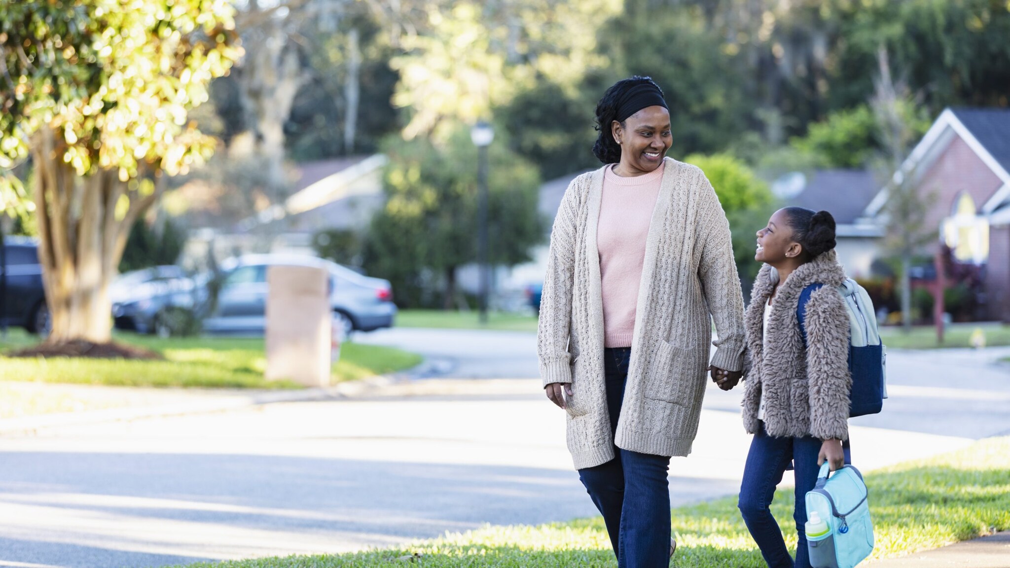 Mom and daughter walk to school.