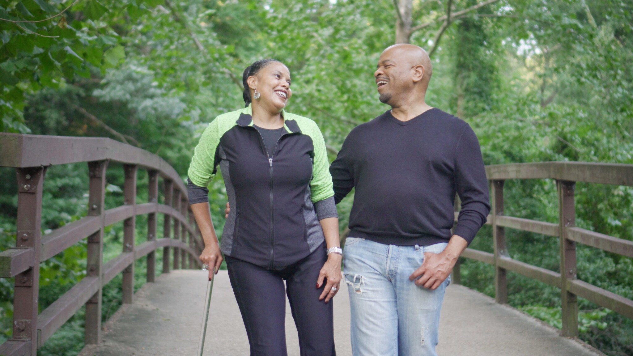 Woman with cane and man walking in nature