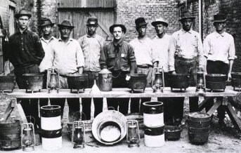 Rat Catchers in New Orleans; Group portrait of nine men standing behind a makeshift table