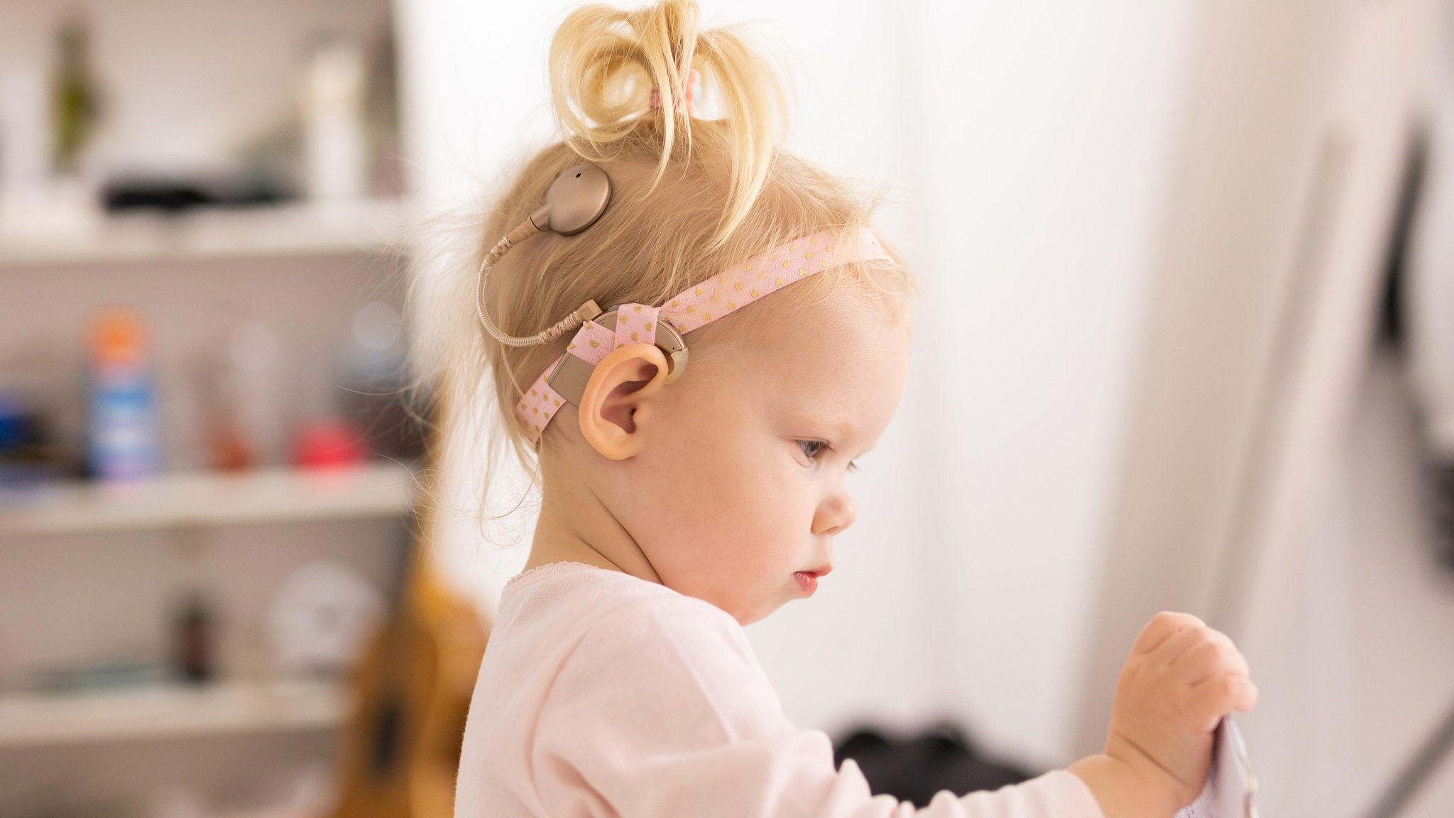 Young girl with a cochlear implant wearing a headband.