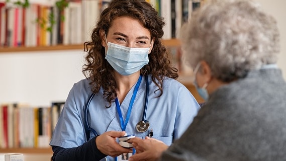 A healthcare providers uses a pulse oximeter to measure an older adult's oxygen saturation.