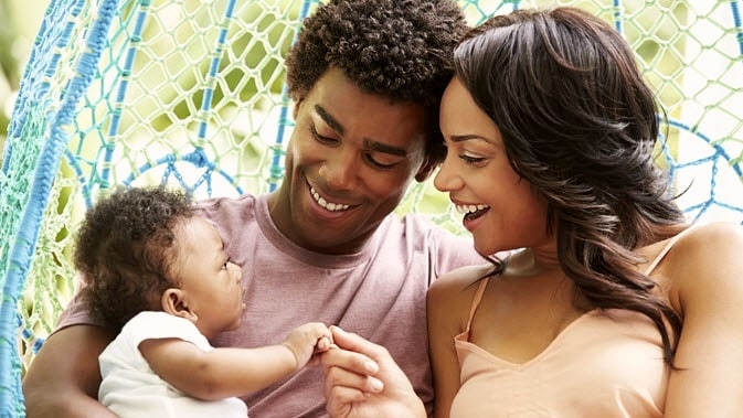 couple holding baby and laughing together