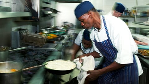 Restaurant chef cooking over a stove.