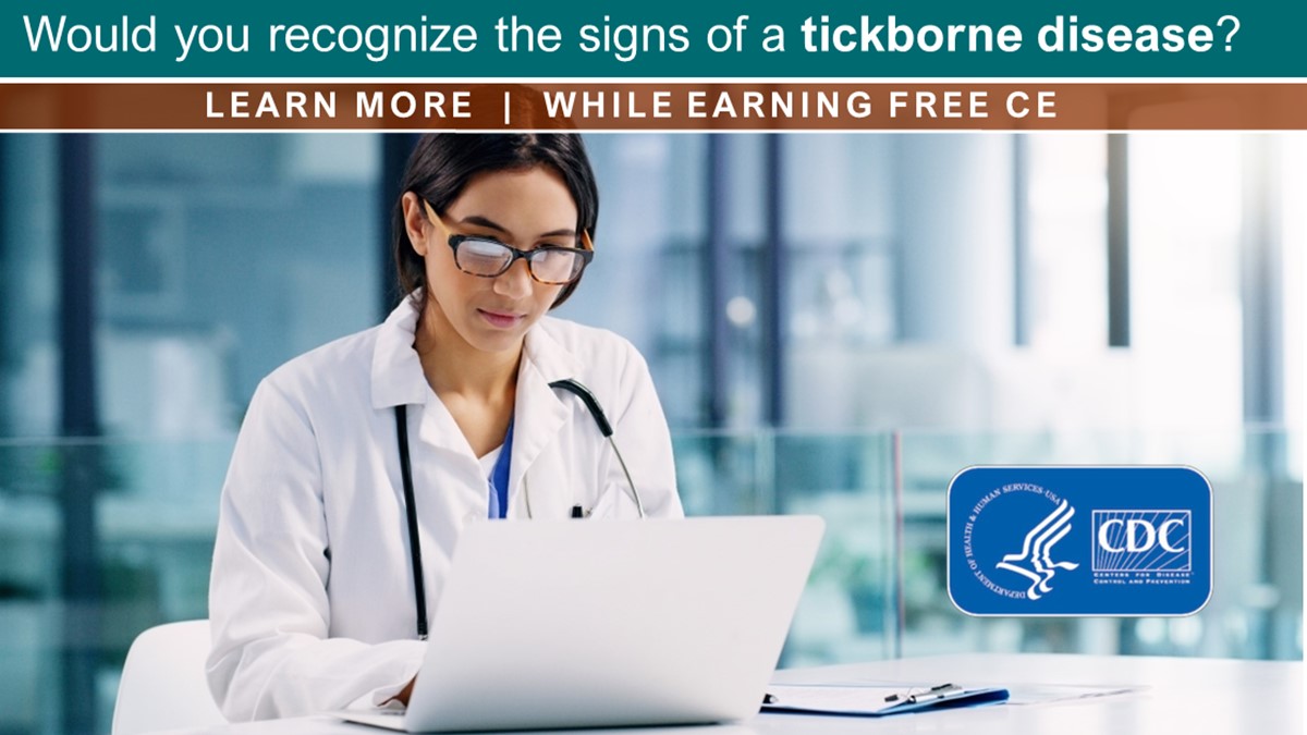 A female healthcare professional at a desk works on a notebook computer.