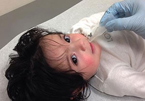 Niña pequeña recibiendo la vacuna contra el rotavirus.