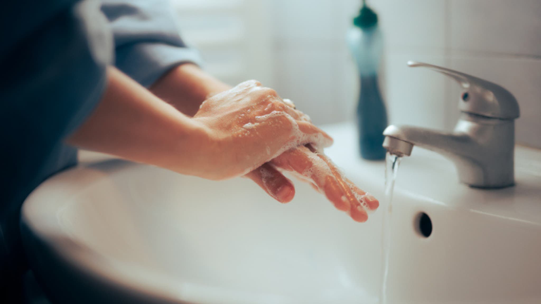 Woman washing hands in bathroom sink