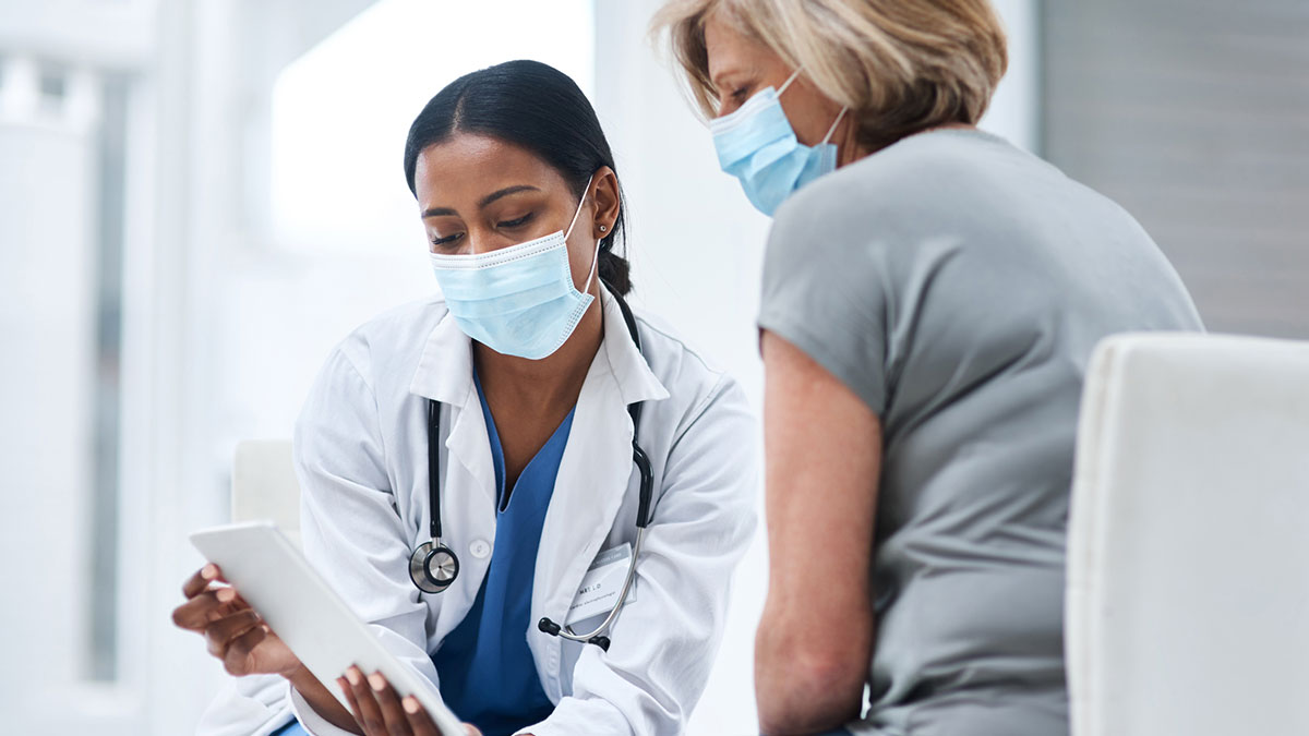 Doctor speaking to adult patient about shingles vaccine.