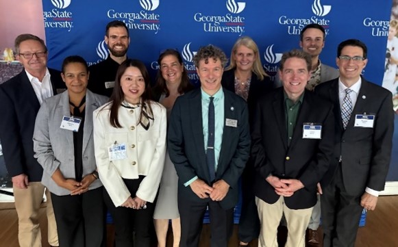 GA SCDC at Project RISE Ten persons pose in front of a Georgia State University backdrop