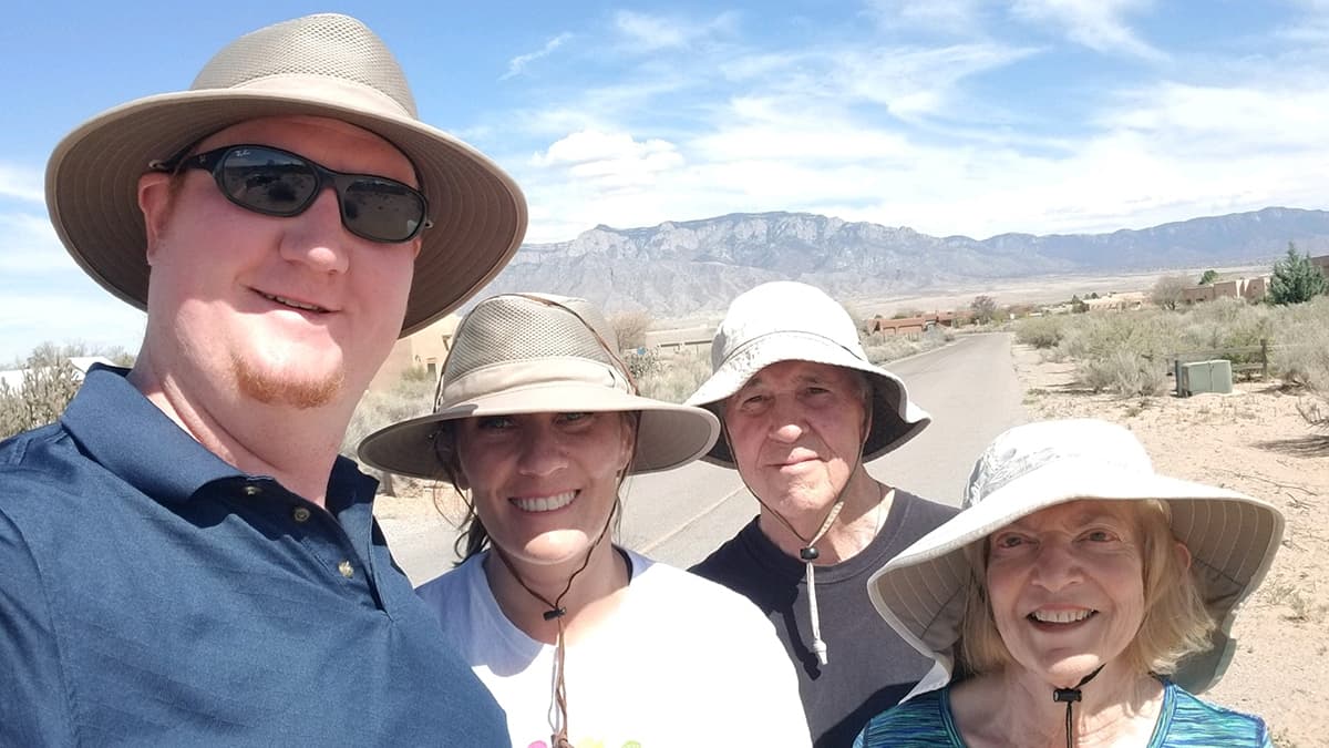 A family showing off their wide-brimmed hats.