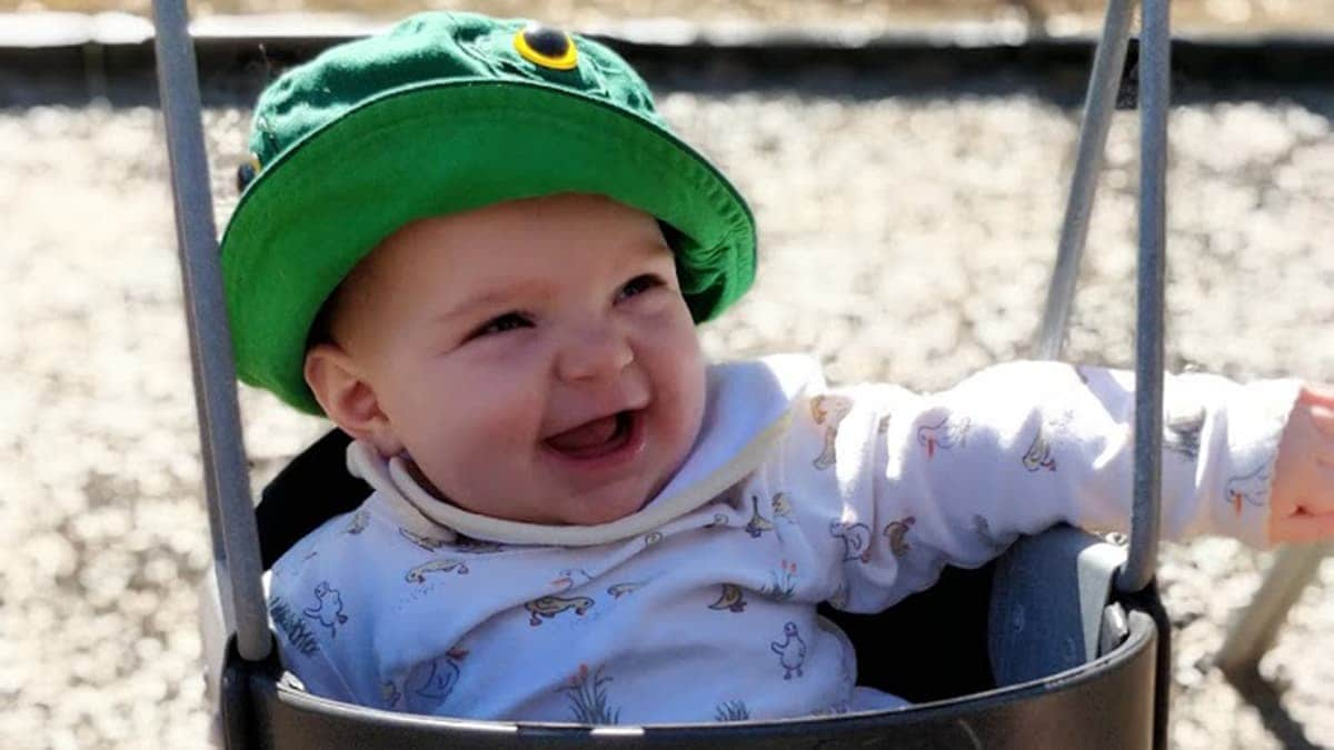 Baby staying sun-safe in a swing.