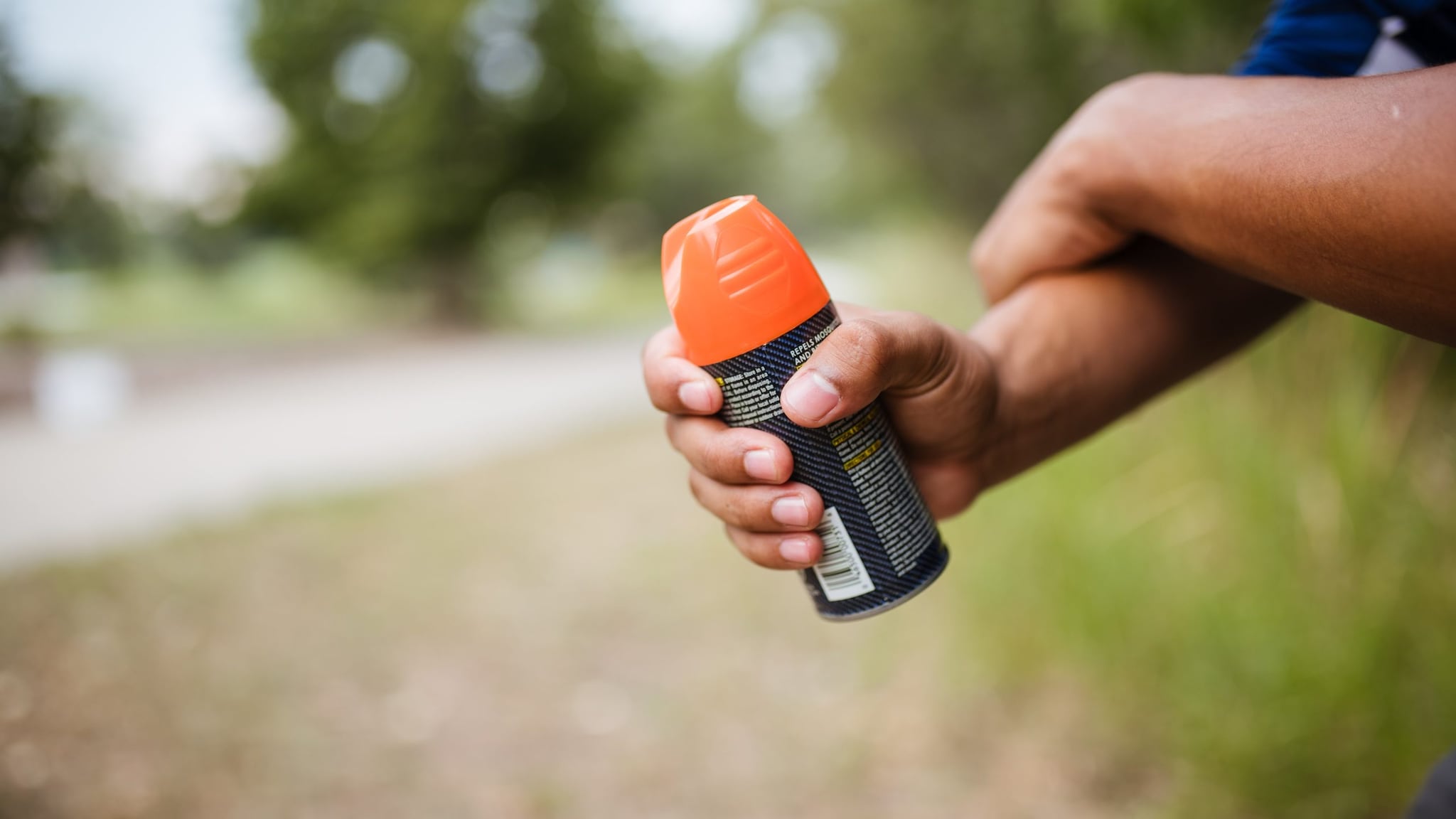 Person rubbing in insect repellent on their arm