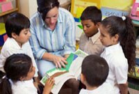 Maestra que lee con un grupo de estudiantes