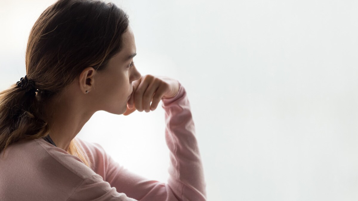 Mujer joven que parece estar triste mirando hacia la distancia.