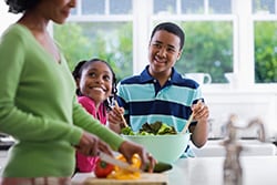 Familia preparando una ensalada saludable.