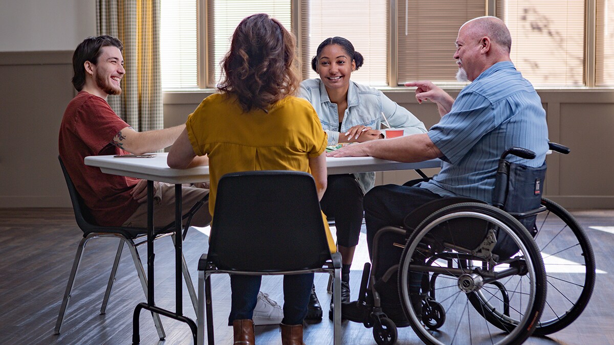 Group of people at a table smiling and having a discussion