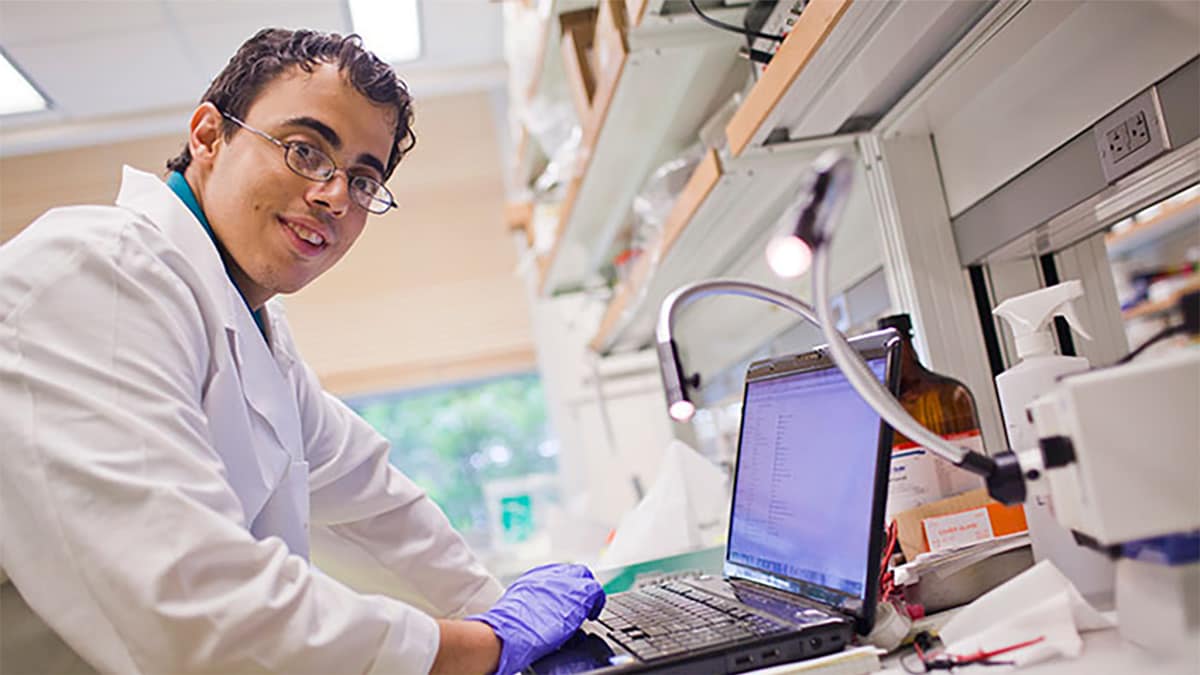 Photo of Robert Mannino working on his laptop in a laboratory