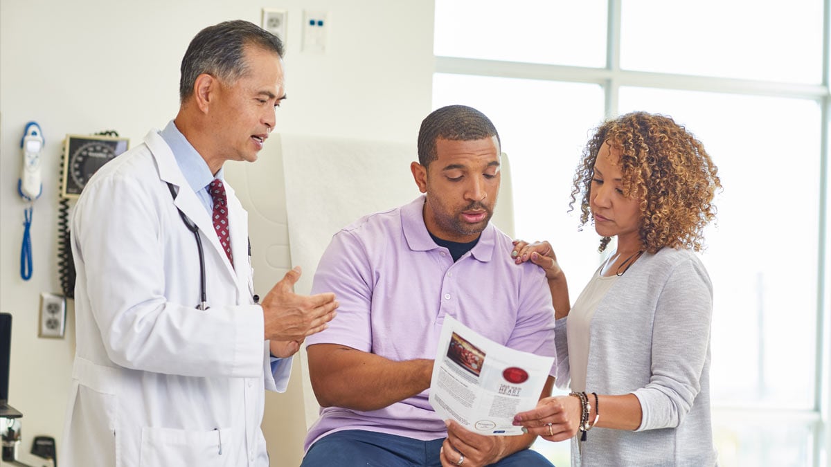 Doctor reviewing cessation materials with patient and spouse