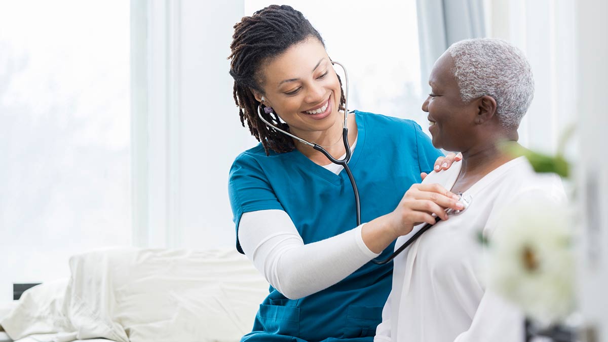 Doctor using a stethoscope to check patient's vitals.