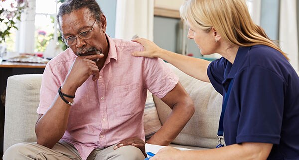 Man being comforted by a therapist.