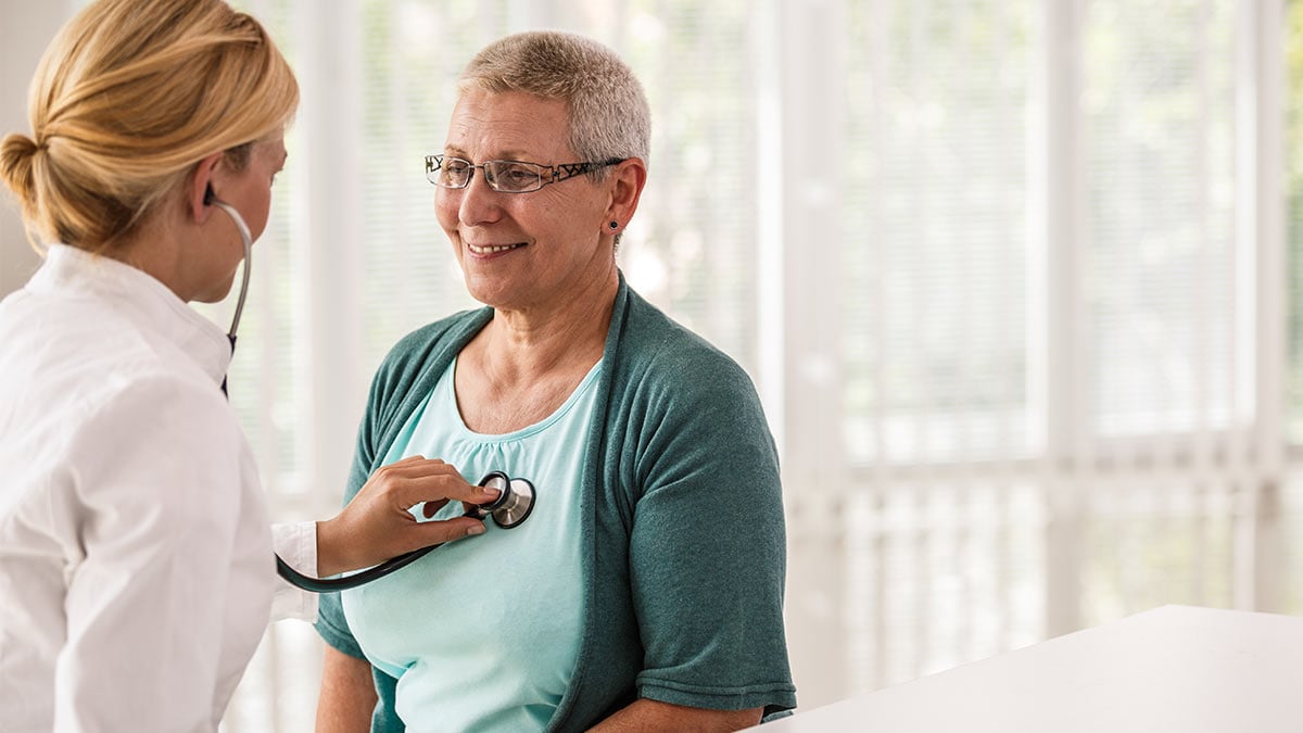 Doctor examining patient using a stethoscope.