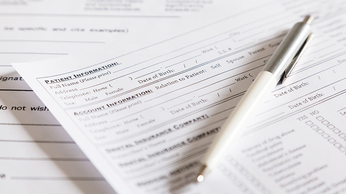 Pen on top of a stack of forms and surveys.