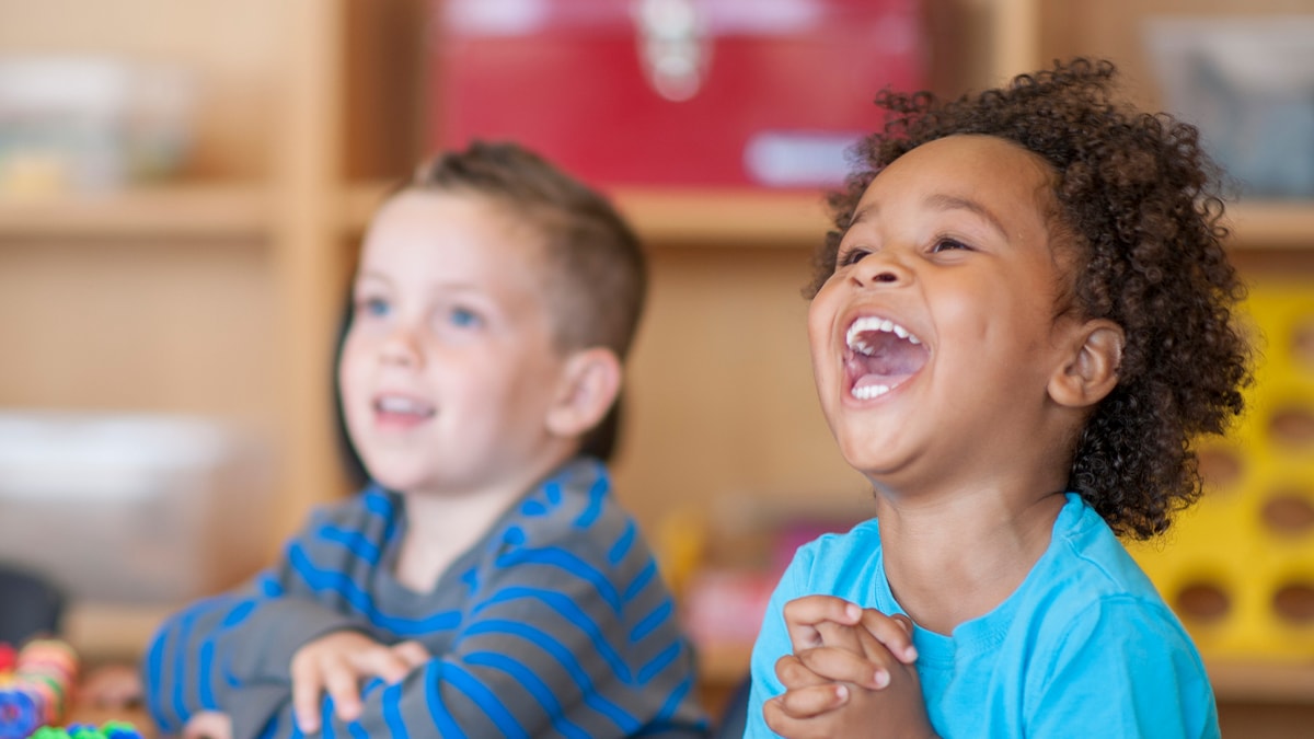 Dos niños sentados a la mesa y sonriendo