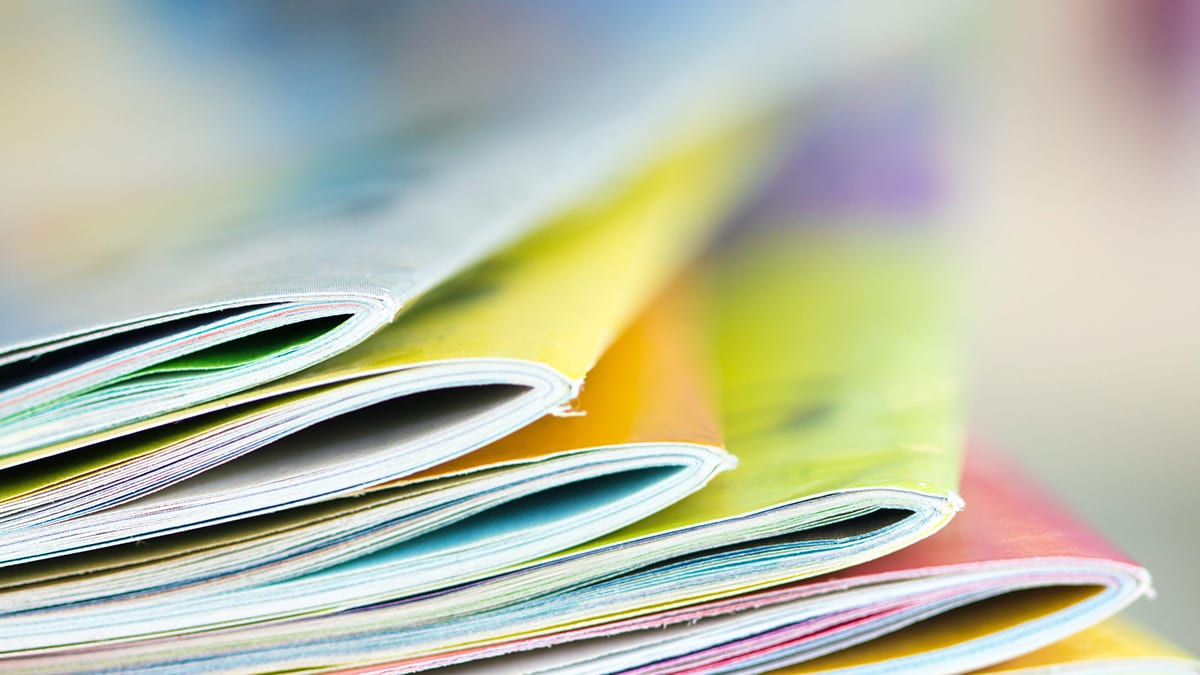 A stack of colored printed materials on a desk.