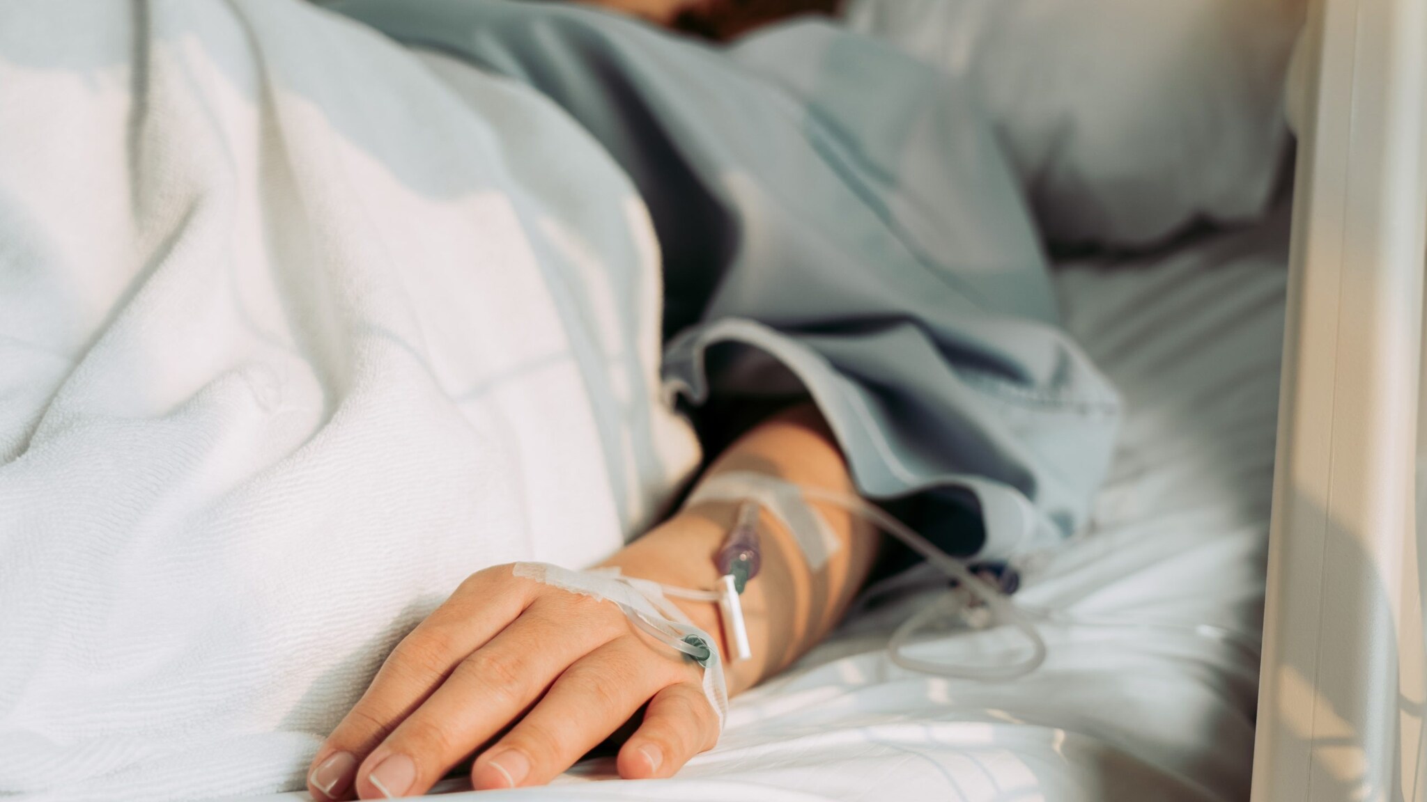 A patient lies in a hospital bed.