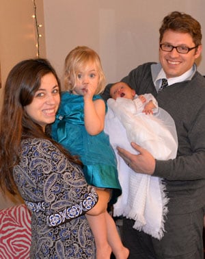 Olive's mother holding a toddler girl and her father holding baby Olive