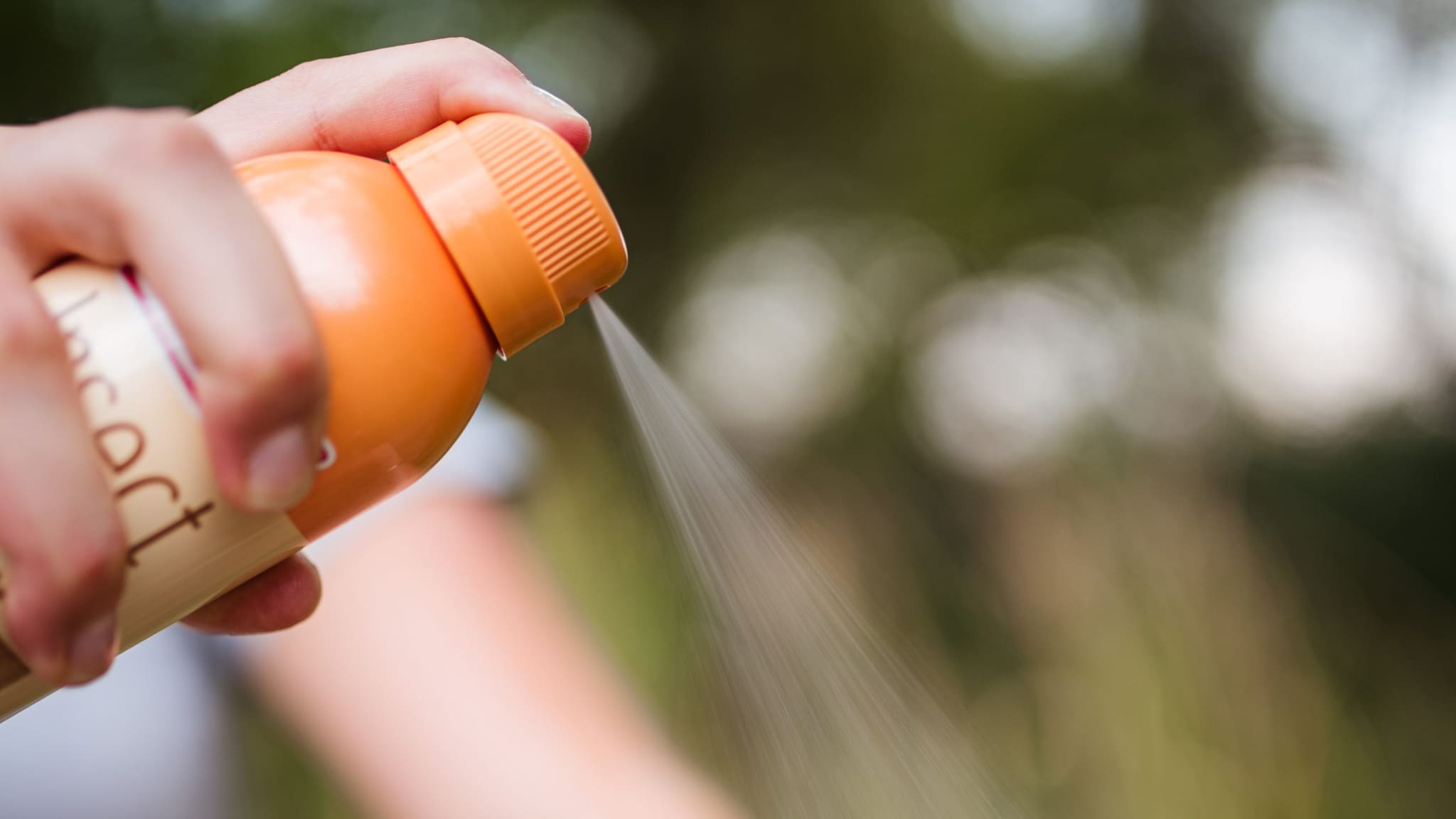 Person spraying insect repellent