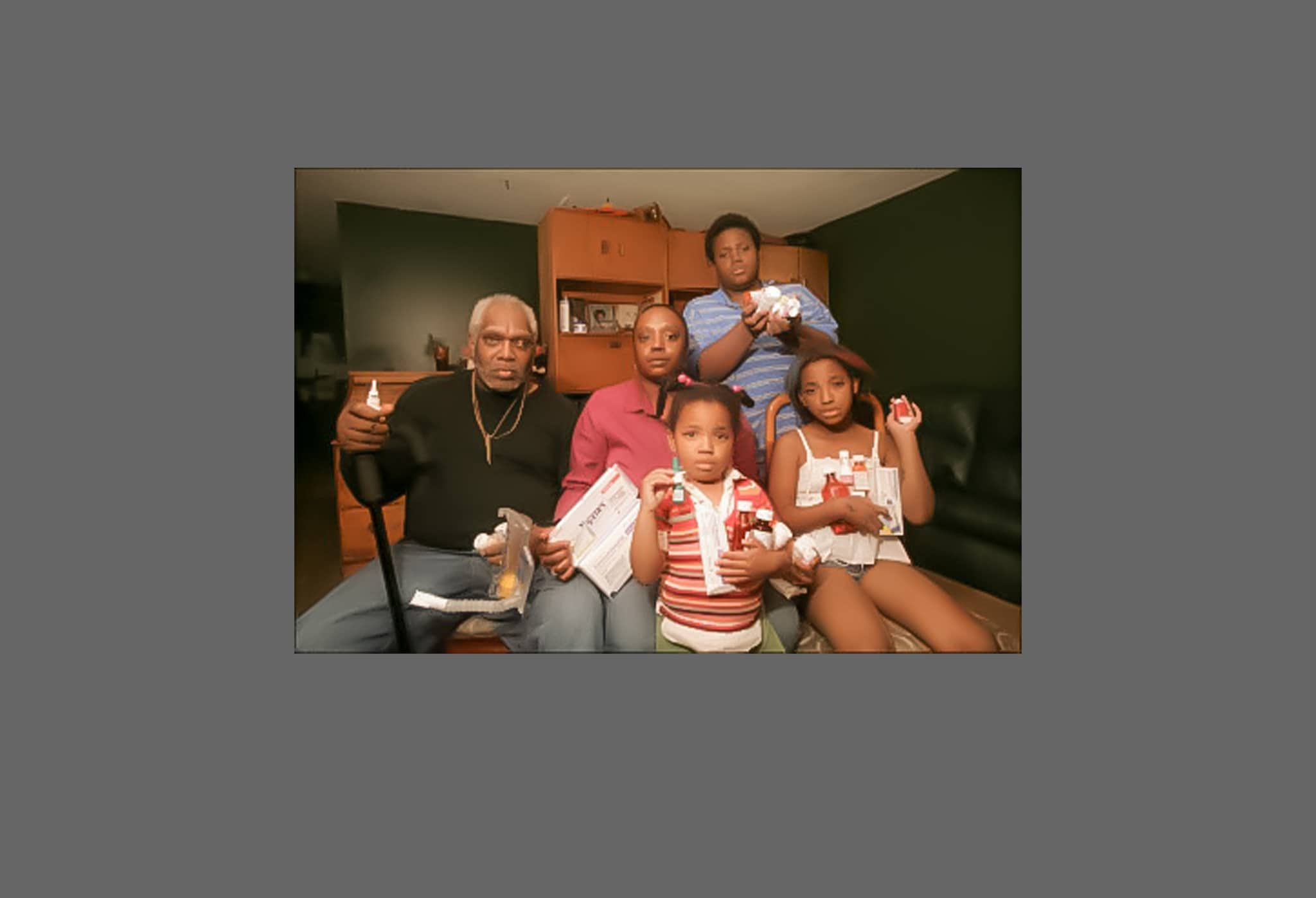 A family holds up medicines they must take for their 9/11 related health issues