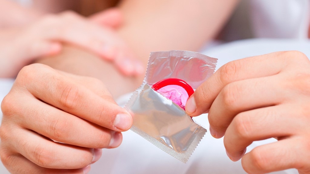 Image of a person opening a male condom.